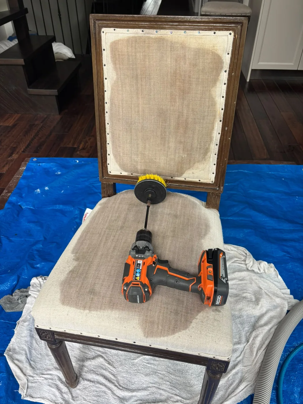 Upholstered chair with cleaning tools on protective covering