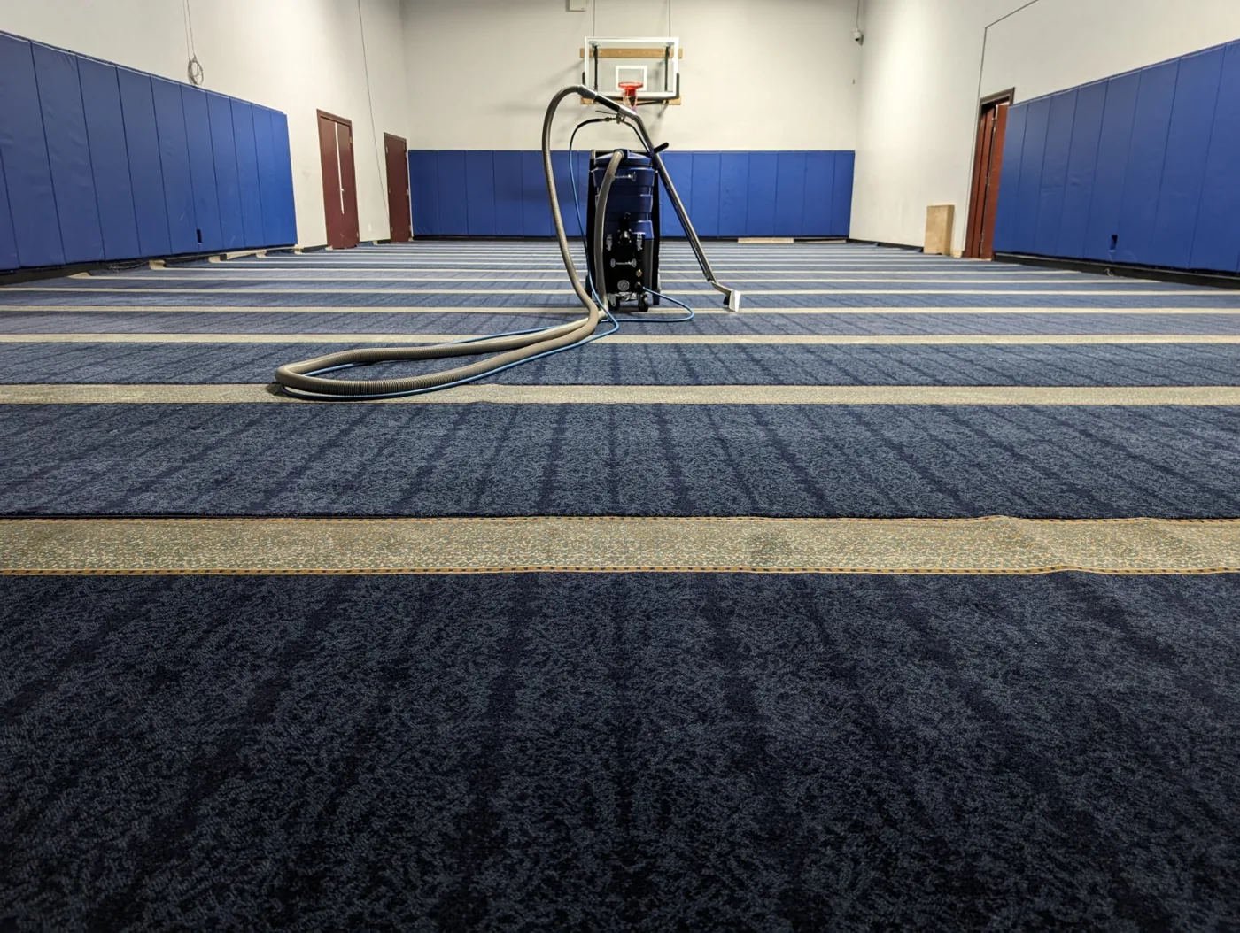 Carpet extractor in a large blue-carpeted hall