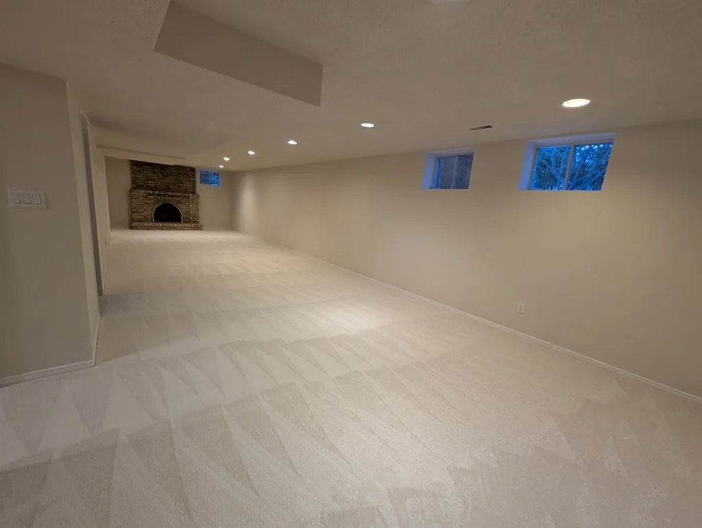 Carpeted residential room with windows and a fireplace