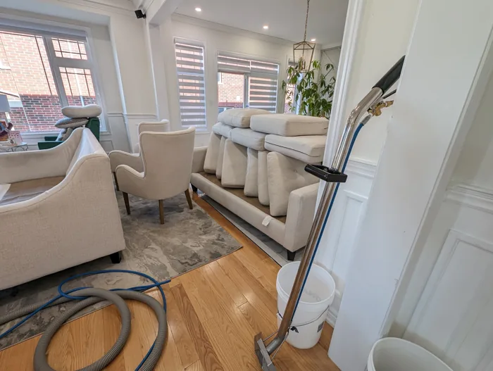 Cream sofas with cushions and cleaning equipment