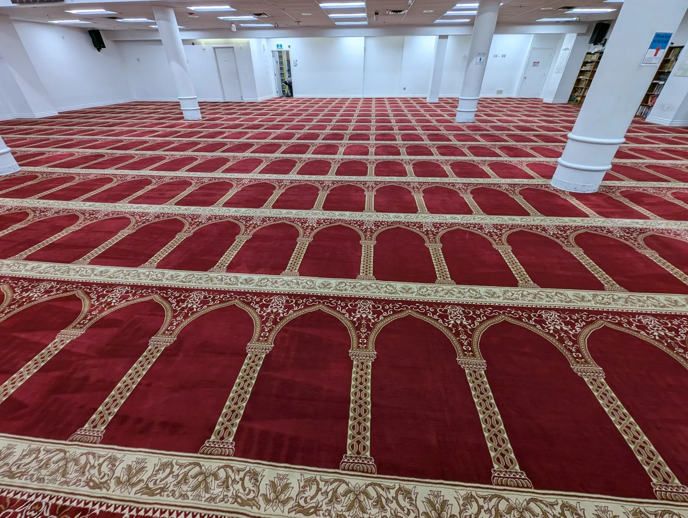 Red patterned carpet across a large prayer hall