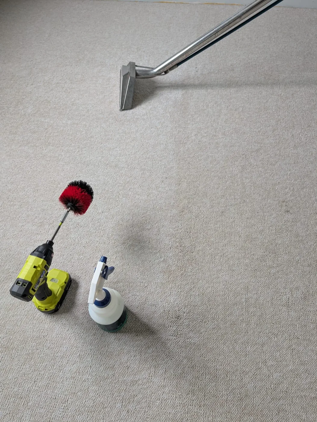 Extraction wand, drill brush and spray bottle on carpet