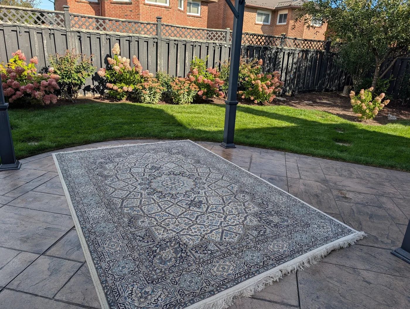 Patterned area rug laid out on a patio
